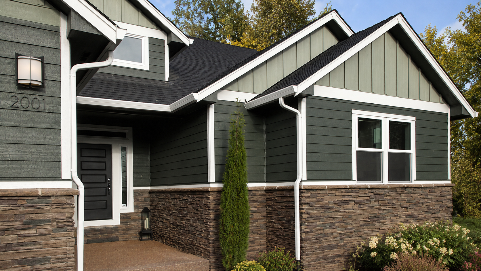Deep green LP SmartSide engineered wood lap and board-and-batten siding with stone wainscot on a Raleigh NC home