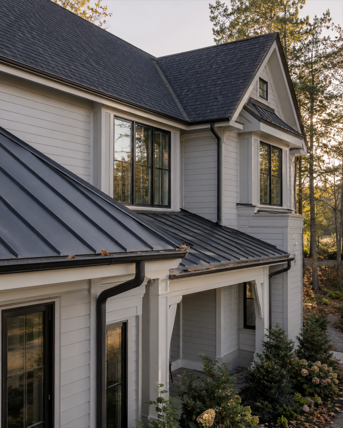 Black standing seam metal roof detail on a white Triangle home at golden hour, installed by Forge Construction Group