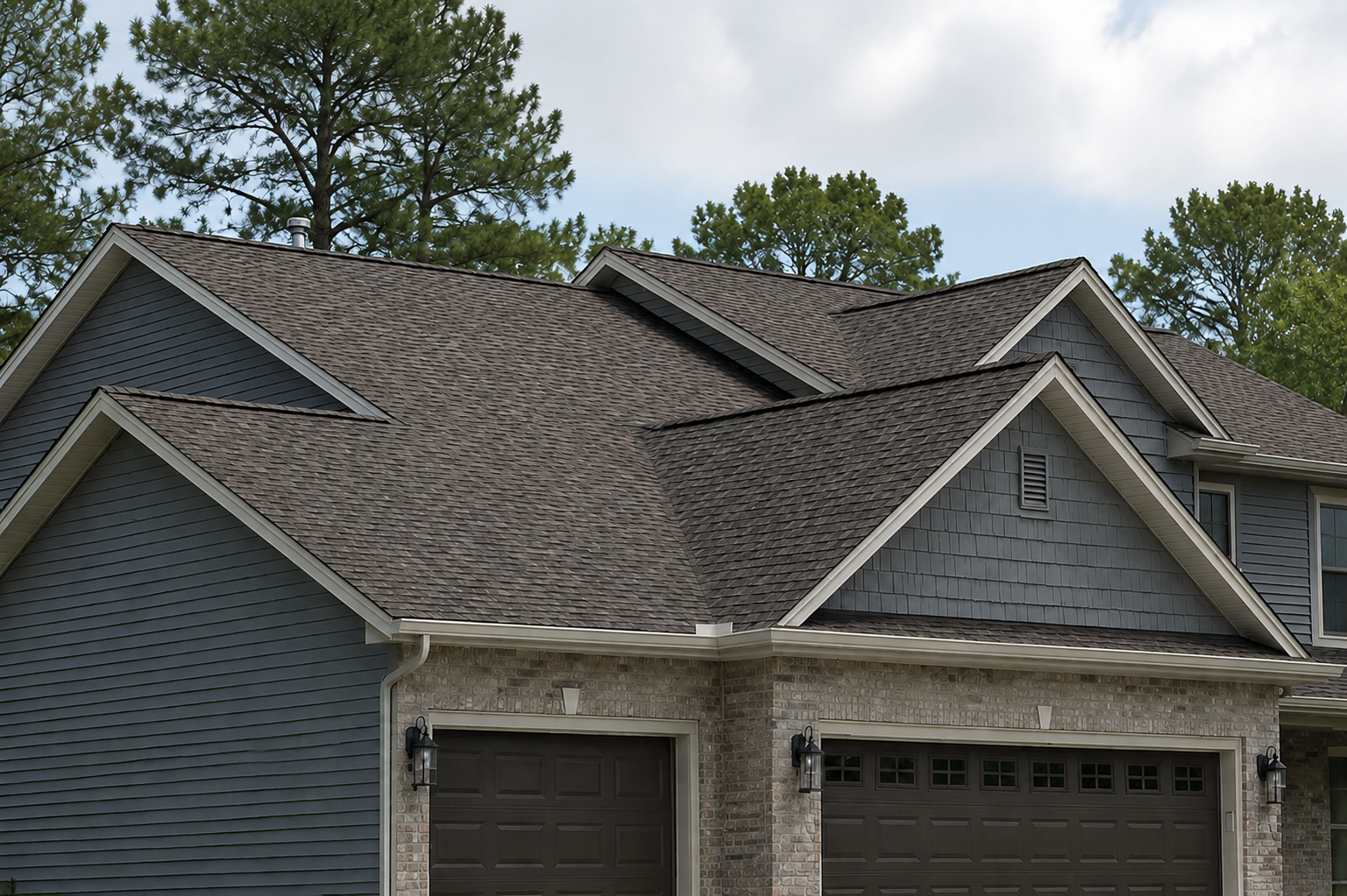 Gray two-story home with an architectural shingle roof and brick garage