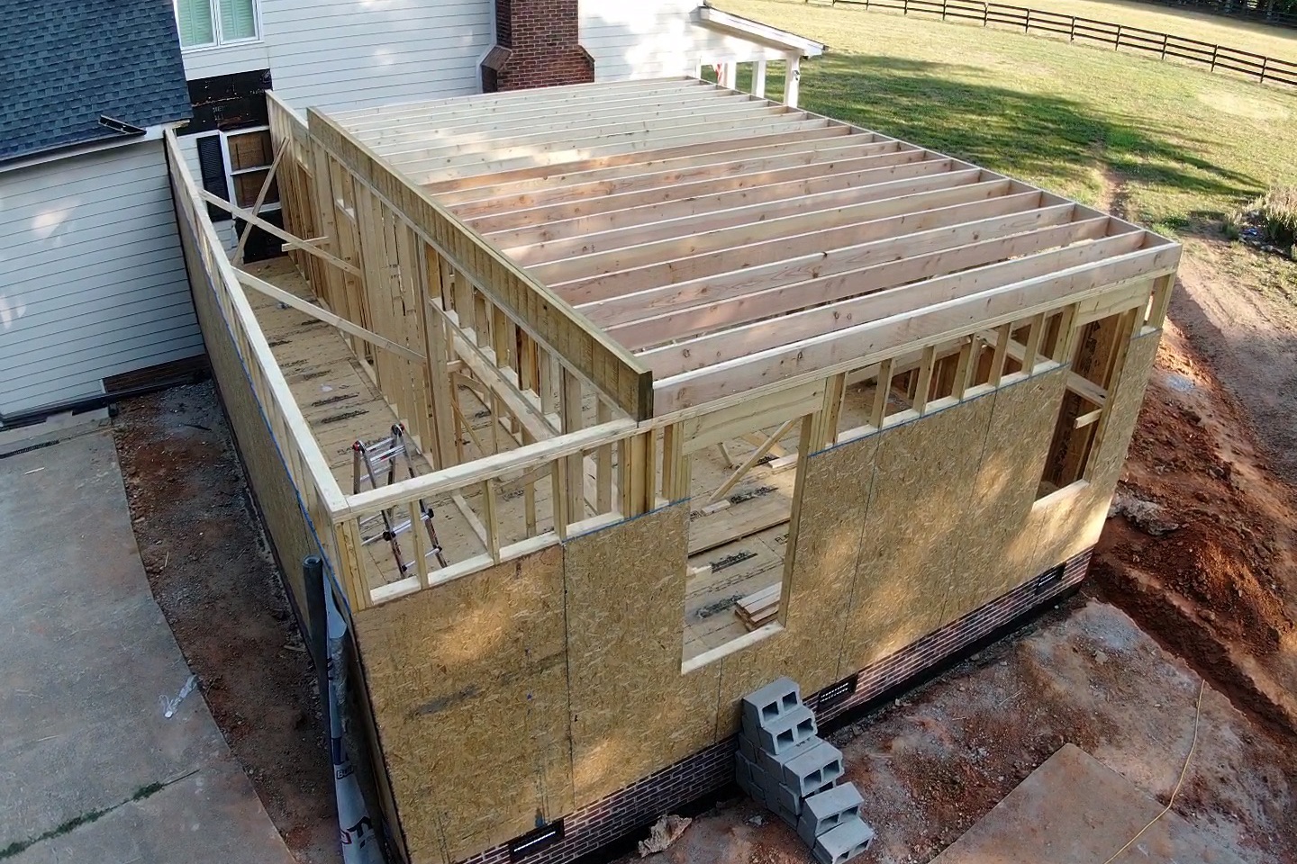 Aerial view of a home addition being framed by Forge Construction Group