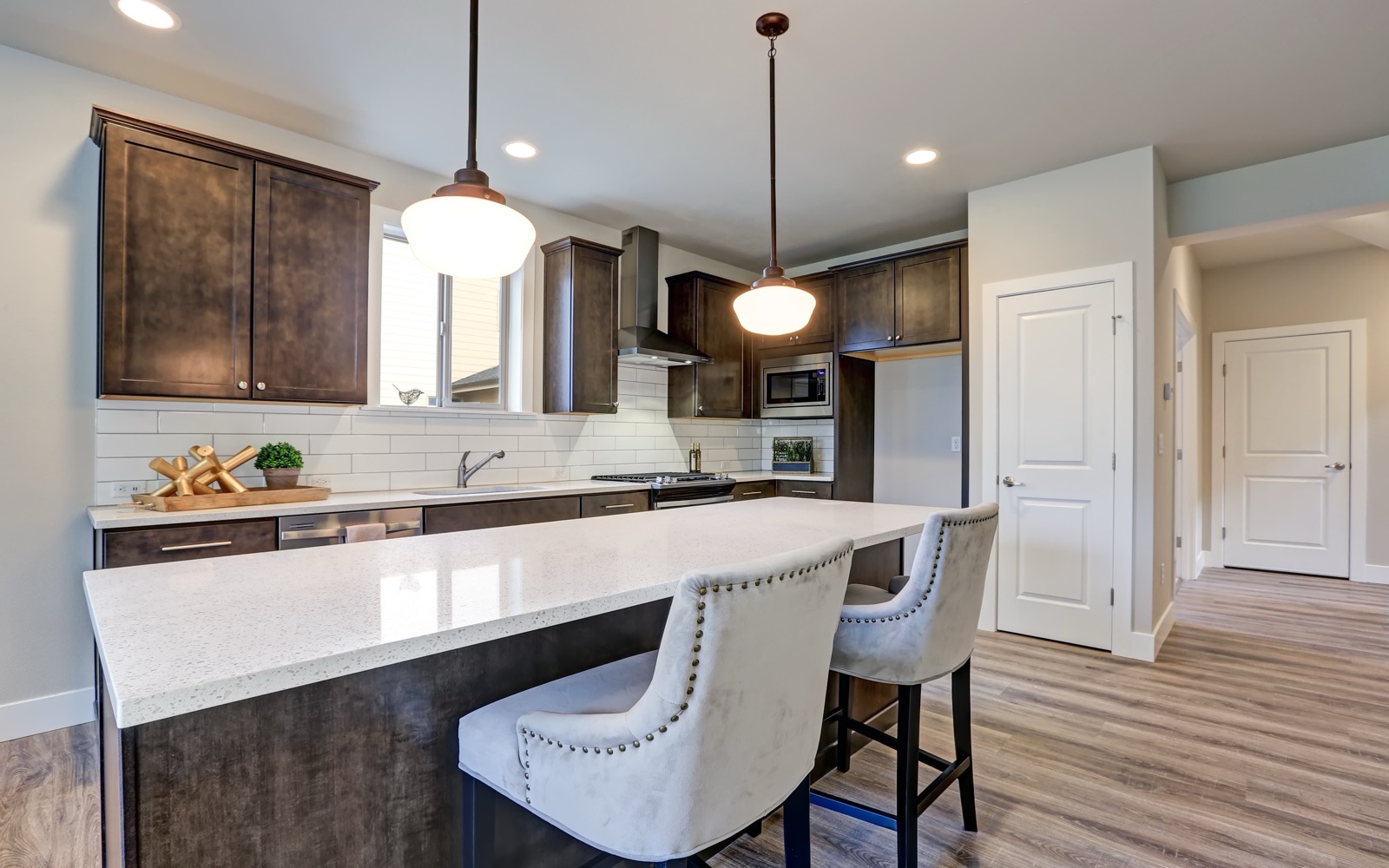 New kitchen with dark wood cabinets and a white quartz island